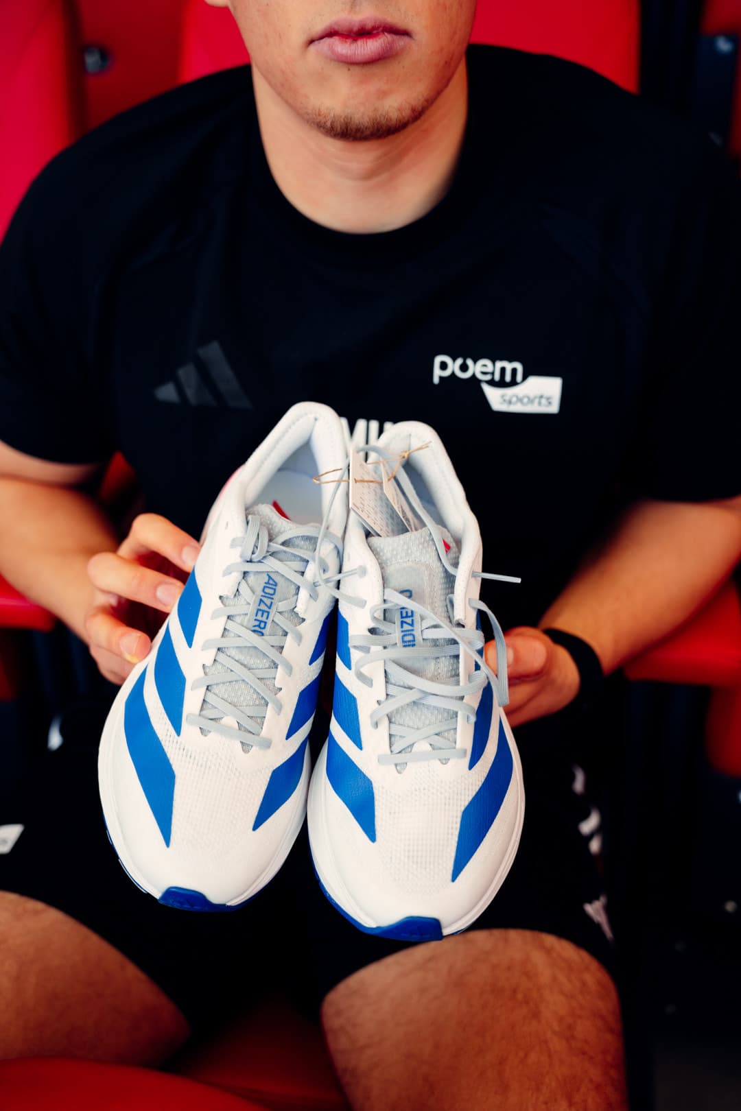 Weiße adidas adizero Laufschuhe mit blauen Streifen, frontal gehalten