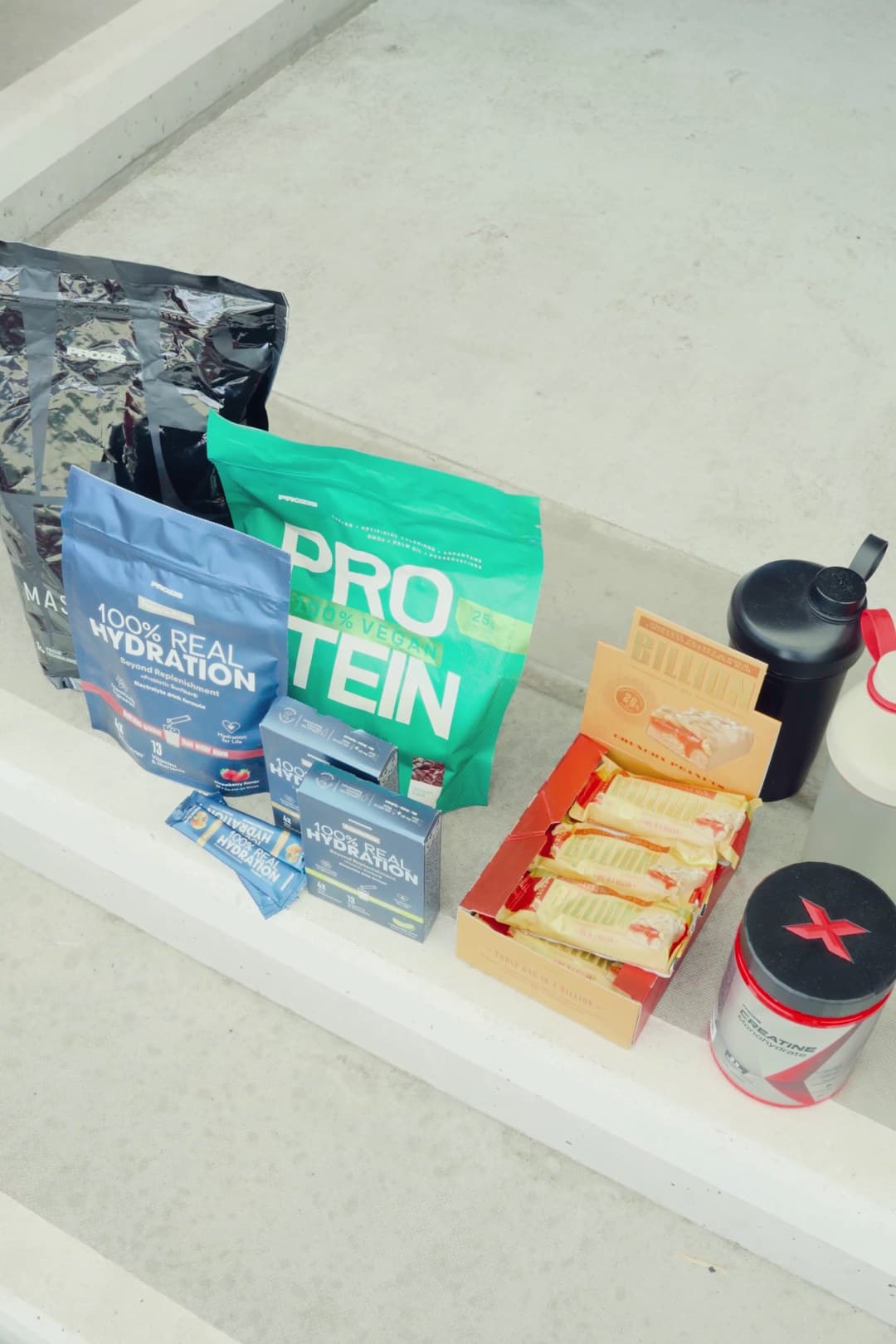 Das Prozis-Paket auf der Stufe: Mass, Hydration, Protein, Sticks, Riegel, Kreatin und Shaker