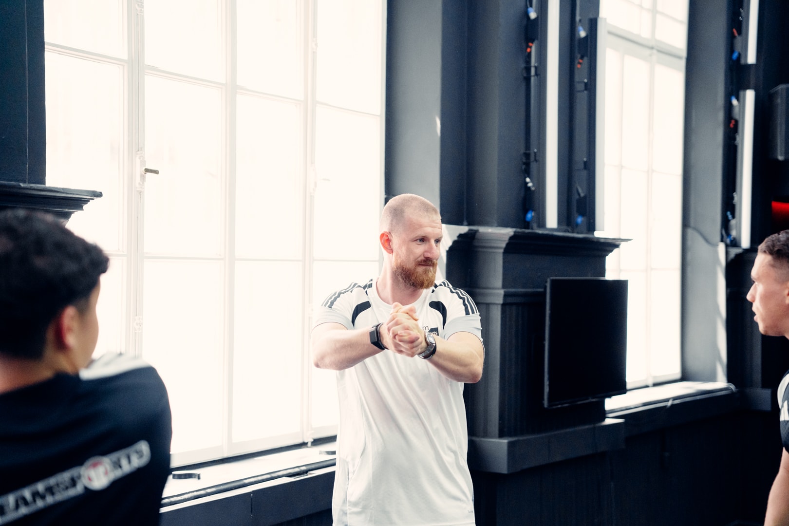Trainer erklärt einer Gruppe Spieler vor der Einheit eine Übung