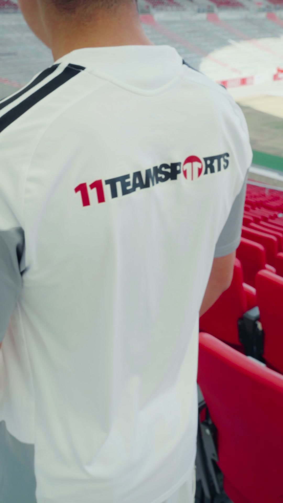 Rückseite des weißen T-Shirts mit 11teamsports-Schriftzug, Tribüne der MHP Arena