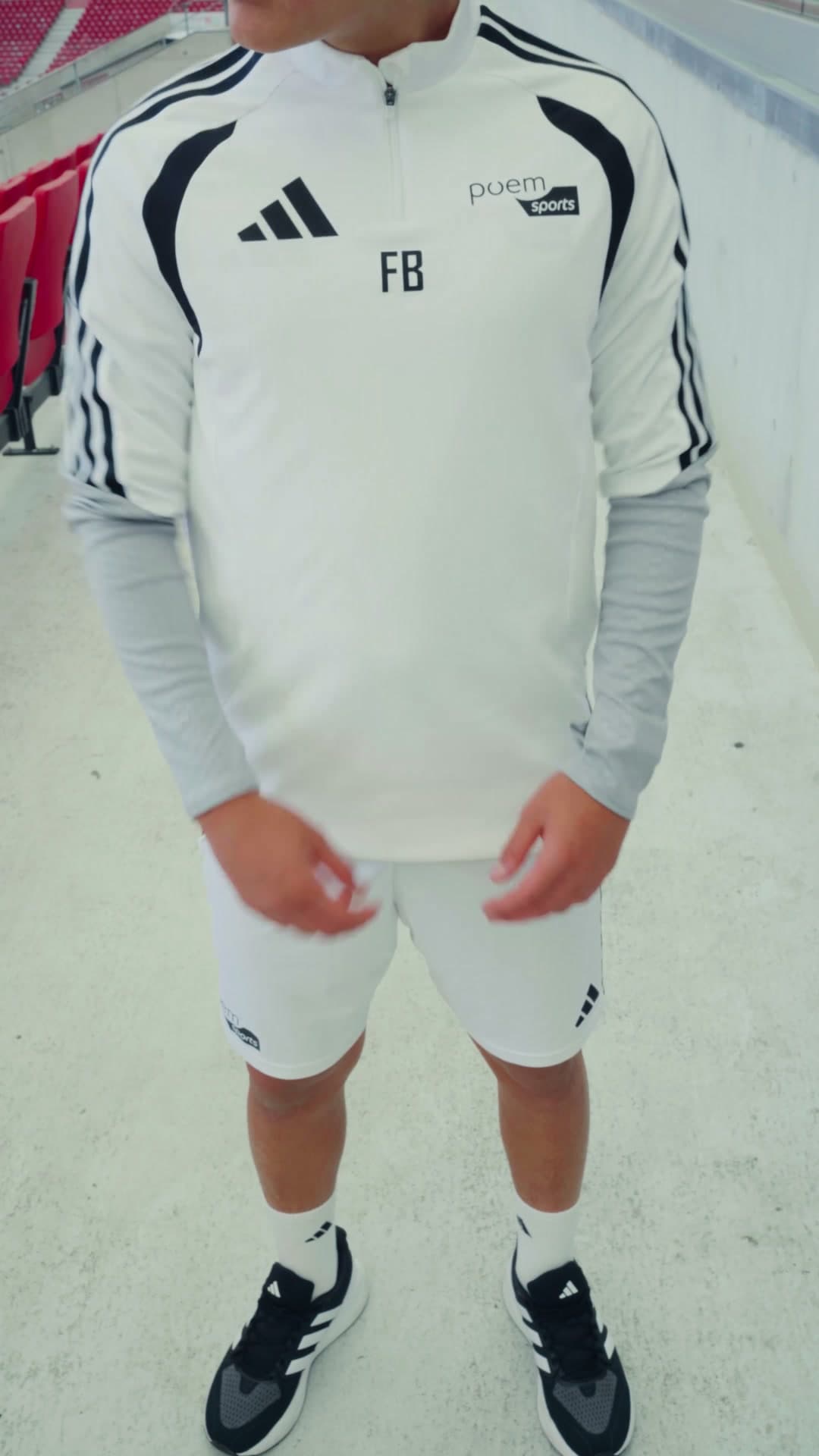 Das weiße poemsports-Kit mit Sweatshirt und kurzer Hose, getragen in der MHP Arena Stuttgart