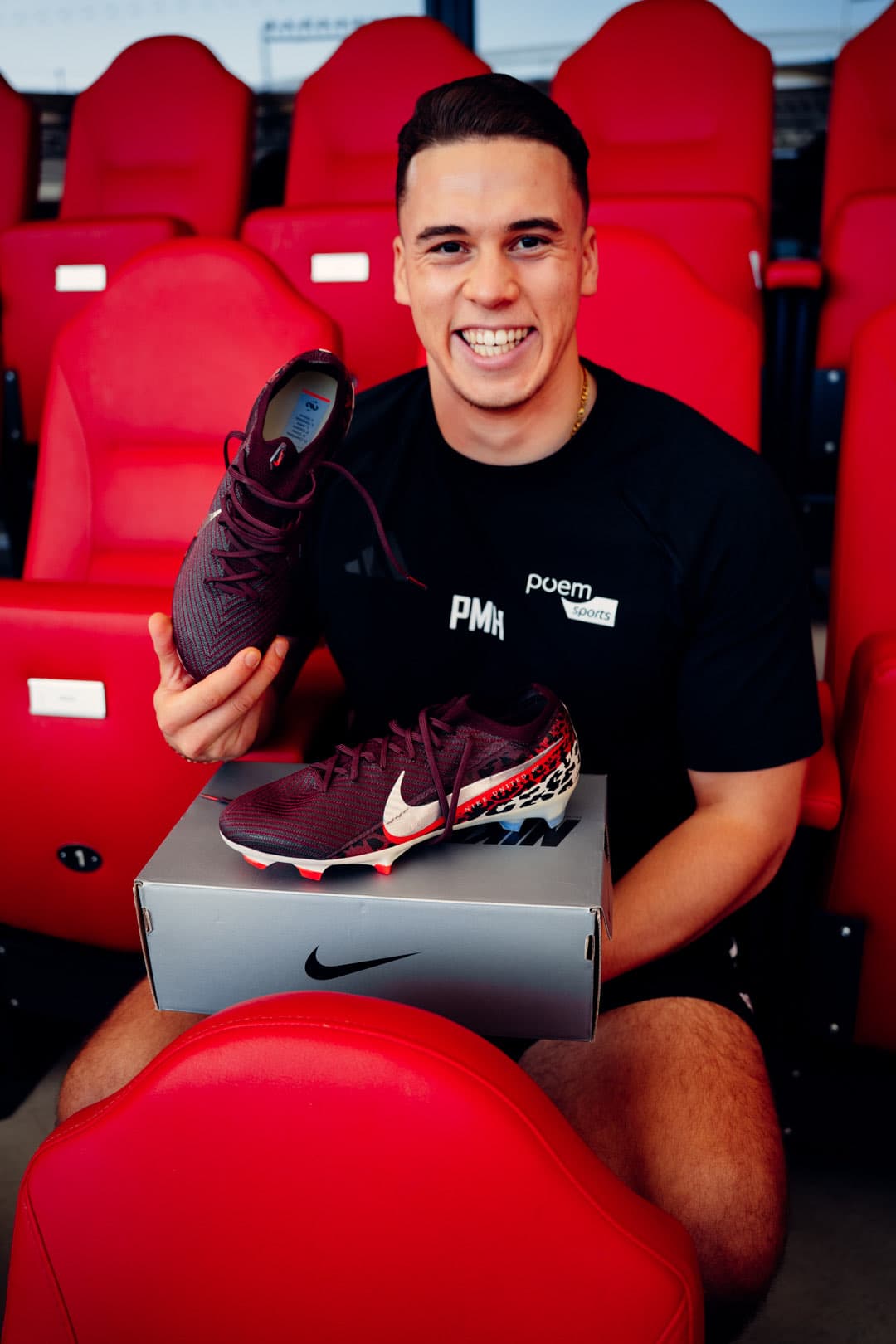 Phil lacht auf den roten Sitzen der MHP Arena, hält weinrote Nike-Fußballschuhe, der Nike-Karton liegt auf seinem Schoß